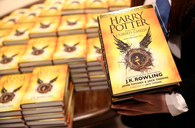 FILE PHOTO: A store assistant holds copies of the book of the play of Harry Potter and the Cursed Child parts One and Two at a bookstore in London, Britain July 31, 2016. REUTERS/Neil Hall/File Photo