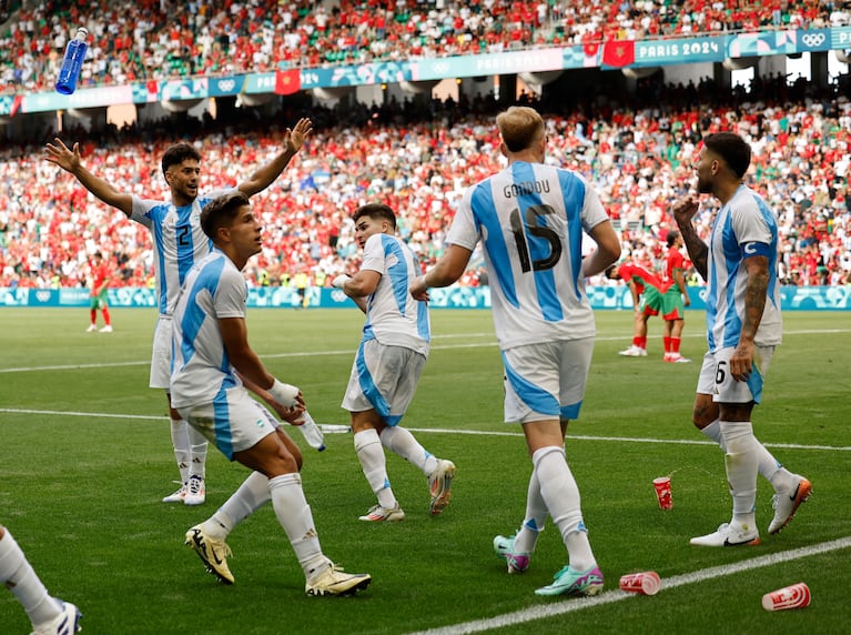 Paris 2024 Olympics - Football - Men's Group B - Argentina vs Morocco - Geoffroy-Guichard Stadium, Saint-Etienne, France - July 24, 2024. Morocco fans throw cups to Argentina players after Cristian Medina of Argentina scores their second goal. REUTERS/Thaier Al-Sudani