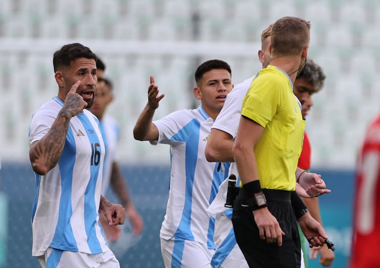 Paris 2024 Olympics - Football - Men's Group B - Argentina vs Morocco - Geoffroy-Guichard Stadium, Saint-Etienne, France - July 24, 2024. Referee Glenn Nyberg talks to Nicolas Otamendi of Argentina during the match. REUTERS/Thaier Al-Sudani