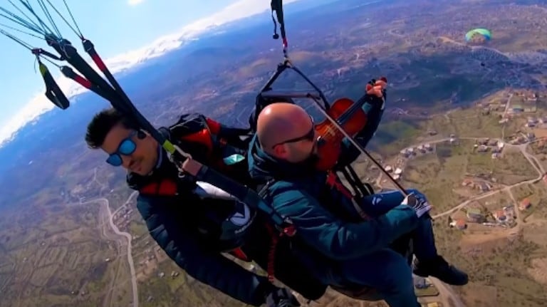 Un hombre vuela en parapente ¡tocando el violín!